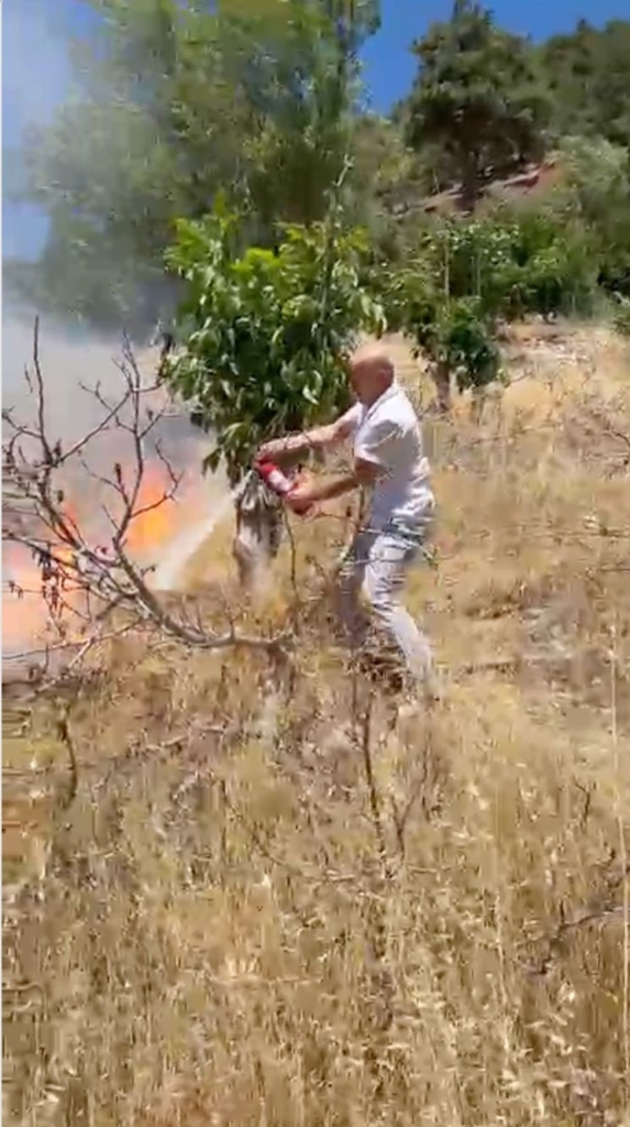 Yangını görüp aracındaki yangın tüpüyle muhtemel orman yangınının önüne geçti
