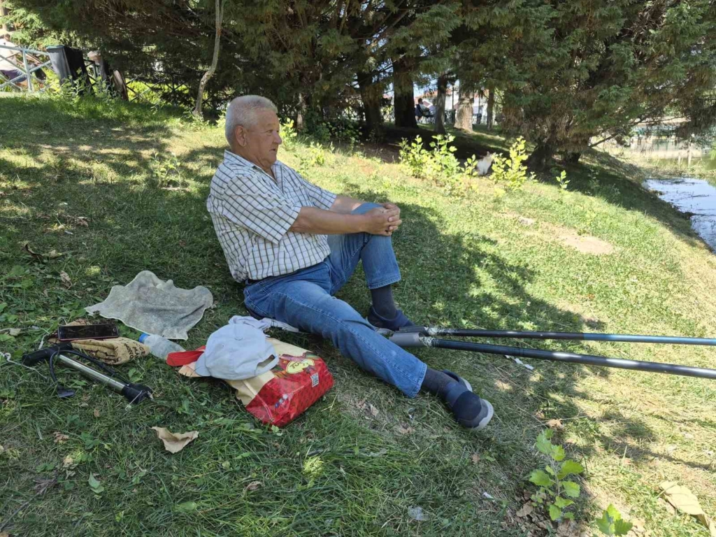 Akıllı sokak kedisi balık tutan adamın başından ayrılmadı