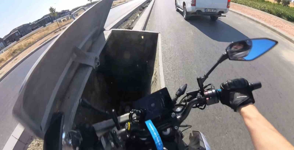 Önündeki aracı sollamaya çalışan motosiklet sürücüsü yola bırakılan çöp konteynerine çarptı