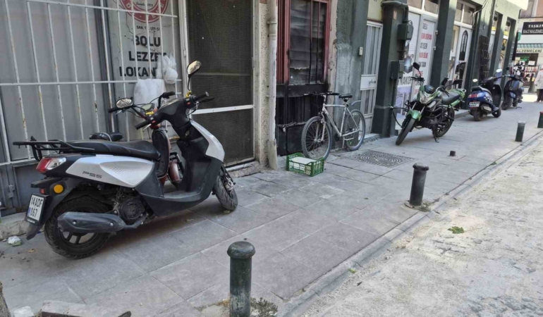 Kaldırımlardaki motosiklet ve konteynerler yayaları yola çıkardı