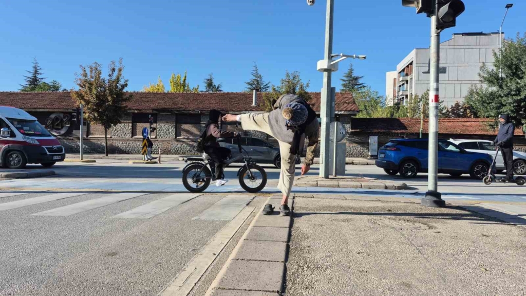 Sokak ortasında uzak doğu dövüş sanatı hareketleri yapan yaşlı adam